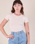 Alex is wearing Baby Tee in Vintage Tee Off-White tucked into light wash Denim Trousers