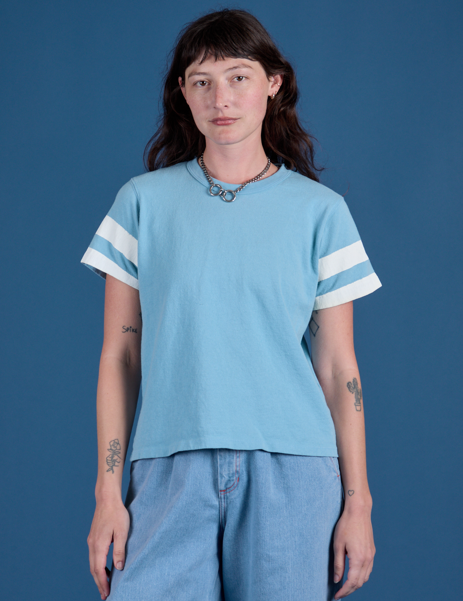 Alex is 5’8” and wearing P Painted Burly Tee in Baby Blue