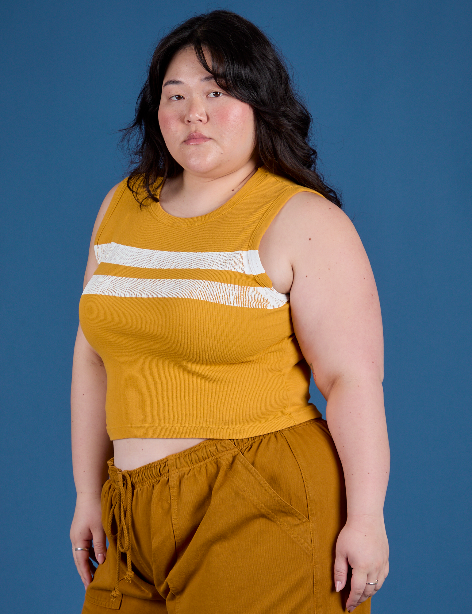 Painted Muscle Tee in Mustard Yellow angled front view on Ashley