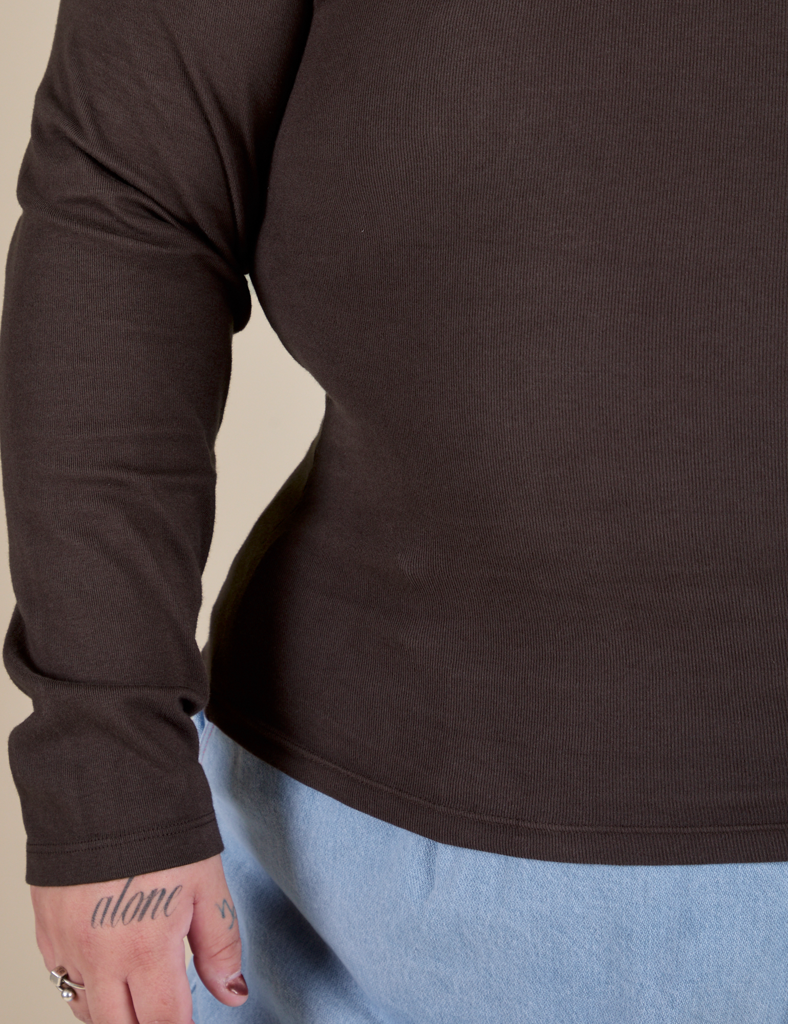 Long Sleeve Baby Tee in Espresso Brown bottom and sleeve close up on Sam