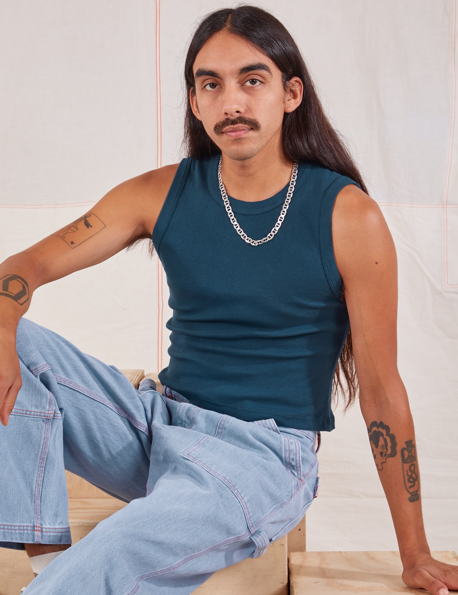 Anthony is wearing Muscle Tee in Lagoon and light wash Carpenter Jeans
