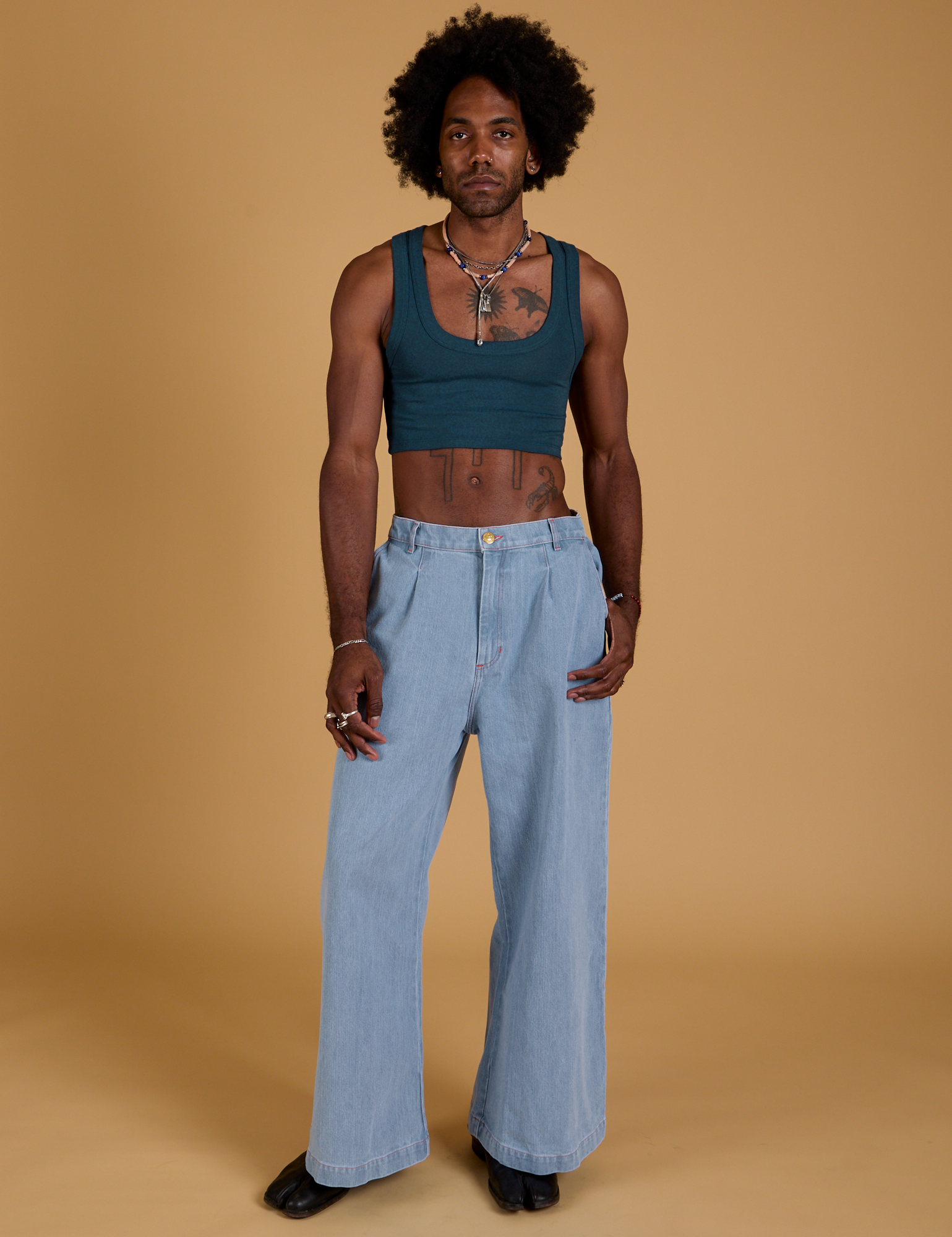 Jerrod is wearing Mini Tank in Lagoon and light wash Indigo Wide Leg Trousers