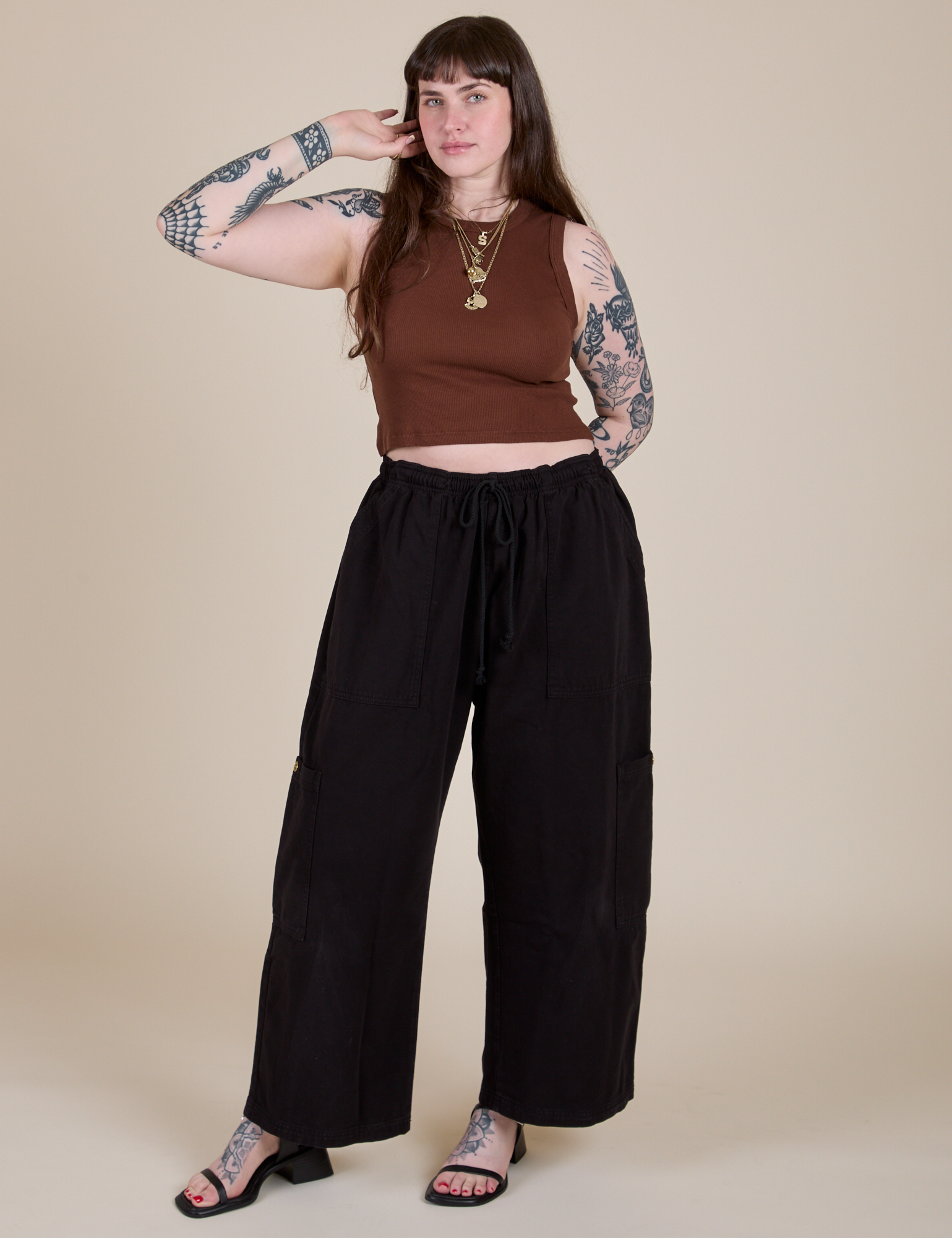 Sydney is wearing Muscle Tee in Fudgesicle Brown paired with black Drop Pocket Cargo Pants