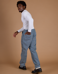 Angled back view of Railroad Denim Work Pants in Natural and long sleeve baby tee in vintage tee white