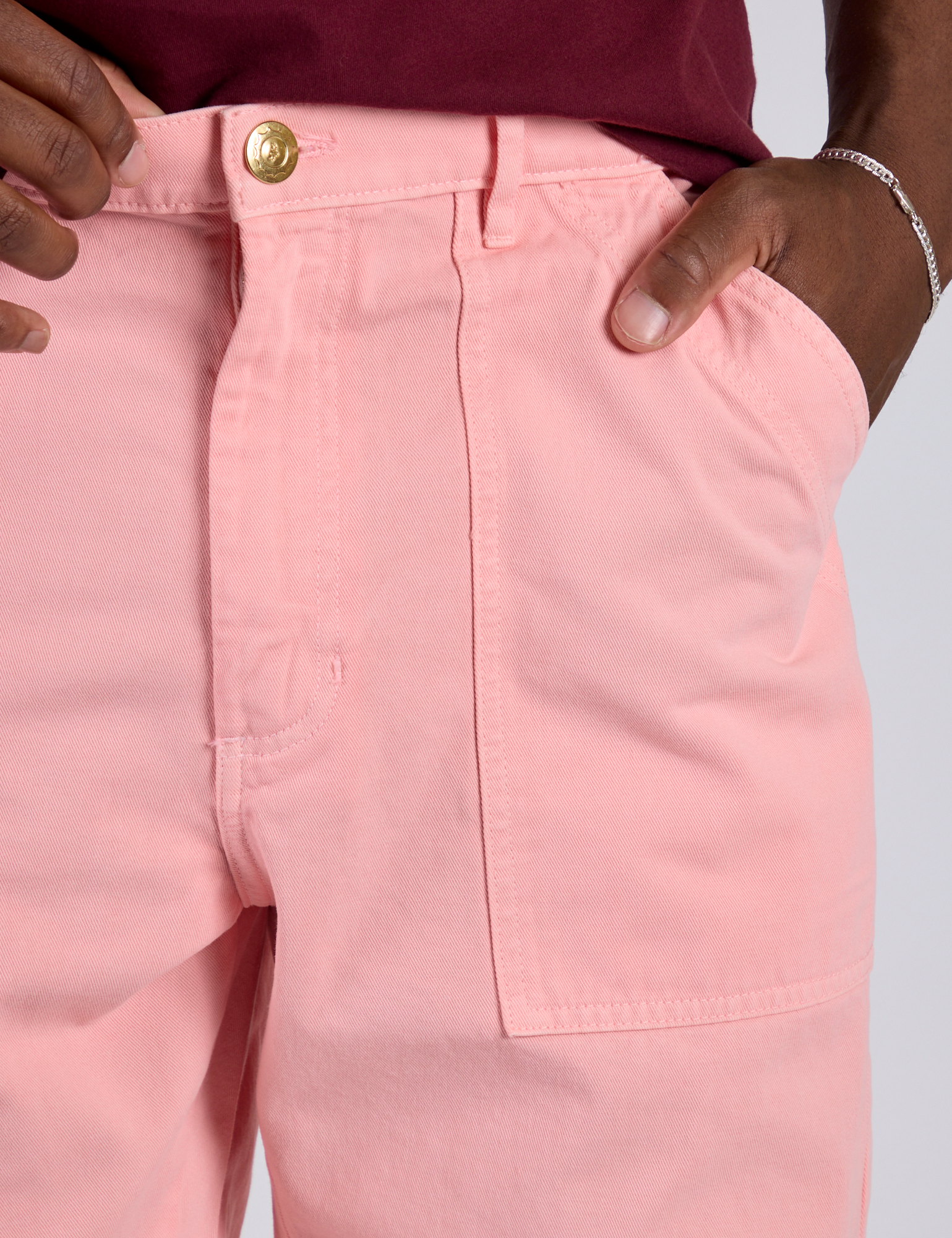Close up of Isaac's hand in the front pocket of Work Pants in Baby Pink