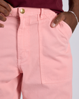 Close up of Isaac's hand in the front pocket of Work Pants in Baby Pink