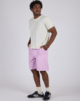 Angled front view of Longline Work Shorts in Lilac Purple and vintage tee white Burly Tee on Isaac