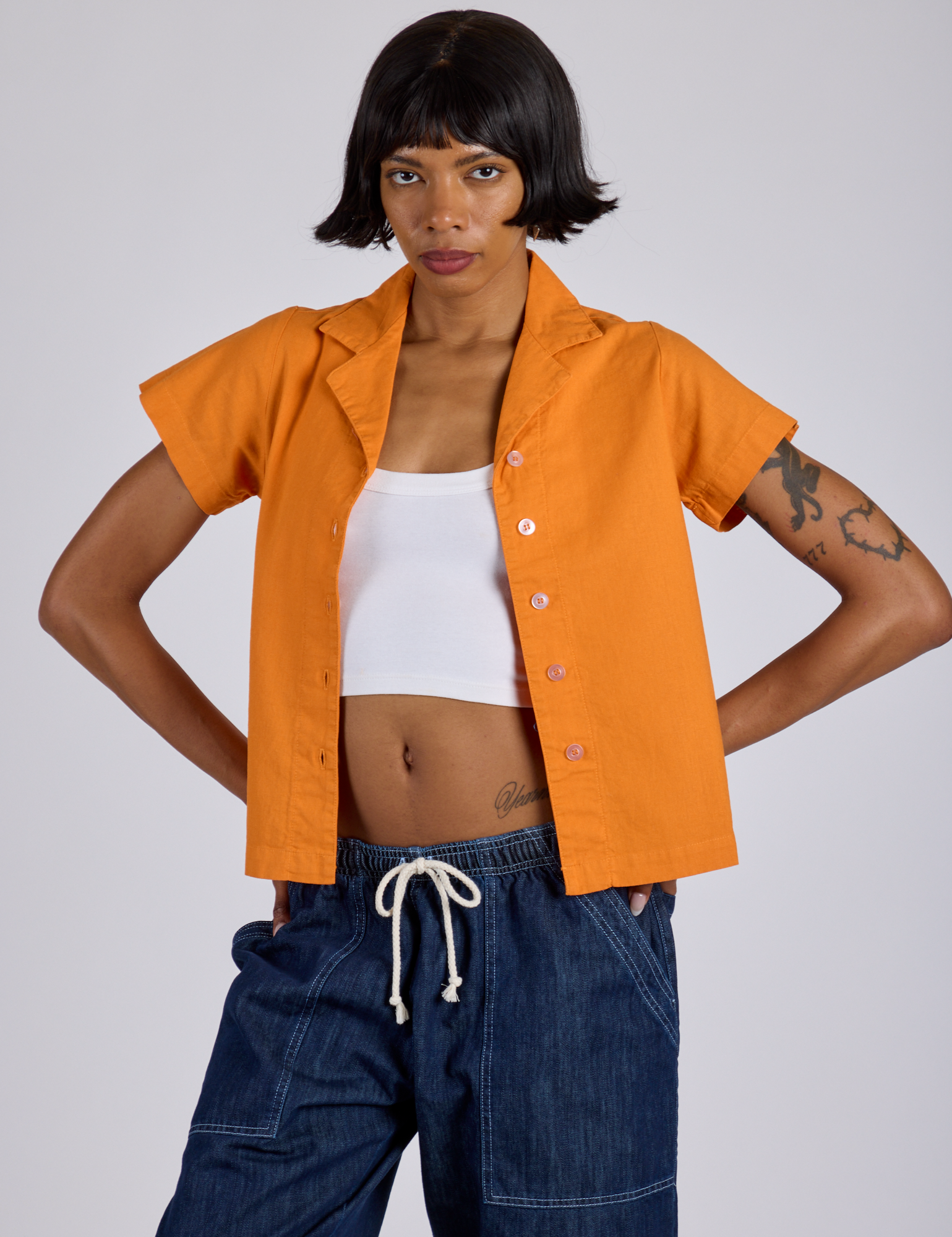 Kira is wearing Pantry Button-Up in Creamsicle Orange