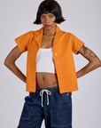 Kira is wearing Pantry Button-Up in Creamsicle Orange