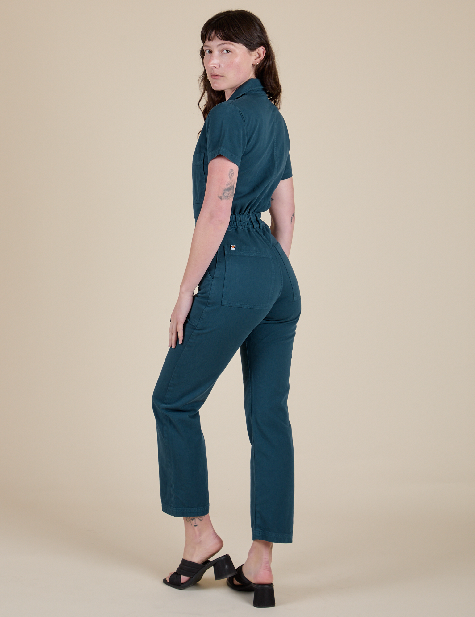 Angled back view of Short Sleeve Jumpsuit in Lagoon on Alex