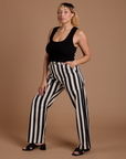 Angled front view of Black Stripe Work Pants in White and black Cropped Tank on Tiara