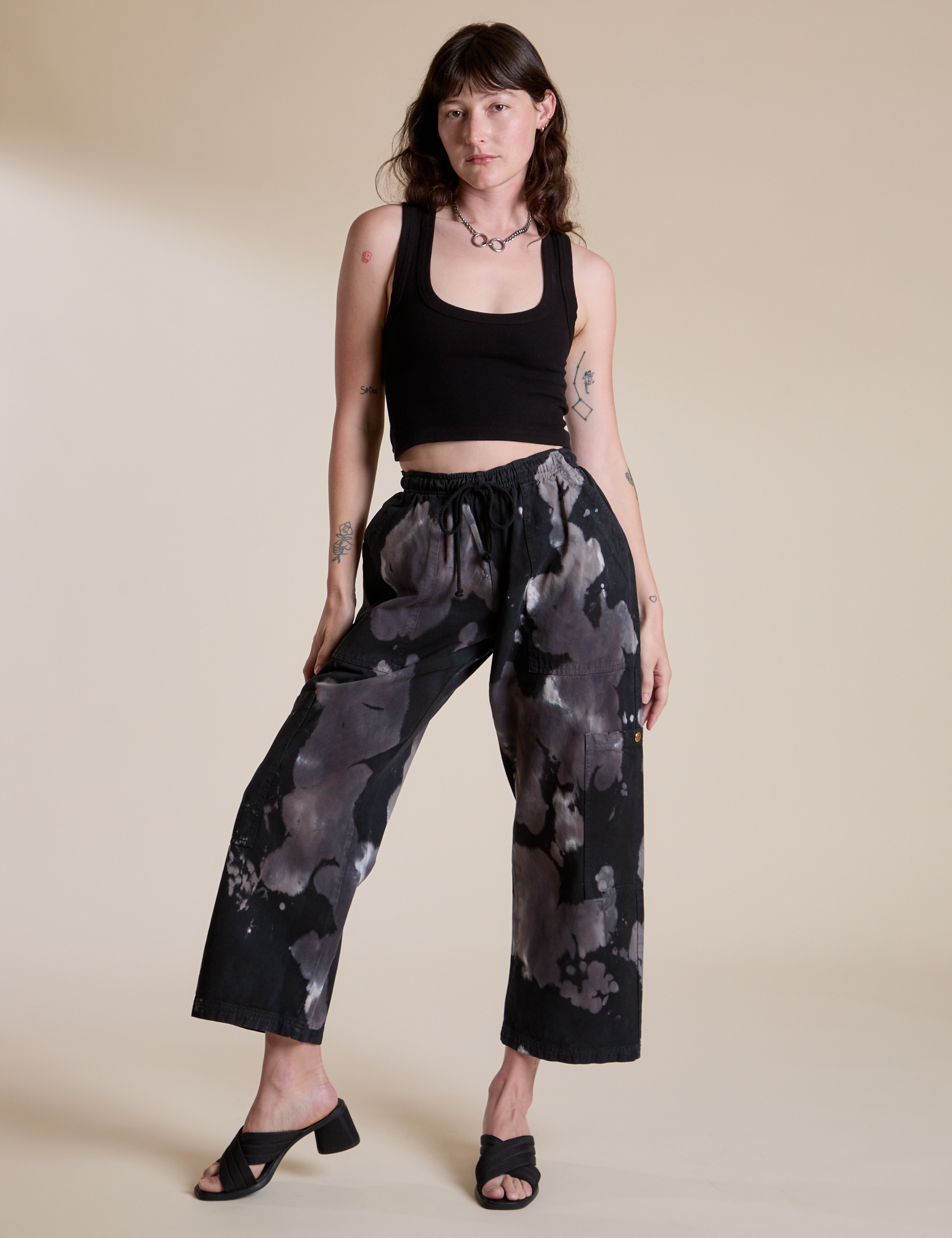 Alex is 5’8” and wearing XXS Magic Waters Drop Pocket Pants in Ink Blot paired with black Cropped Tank