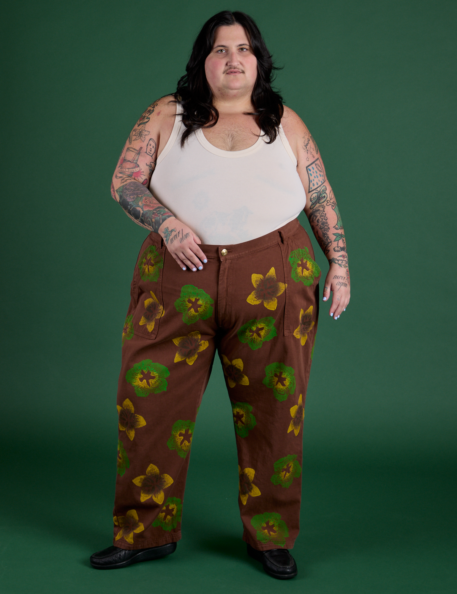 Sam is 5’10” and wearing 4XL Floral Painted Work Pants in Brown paired with a Tank Top in Vintage Tee Off-White