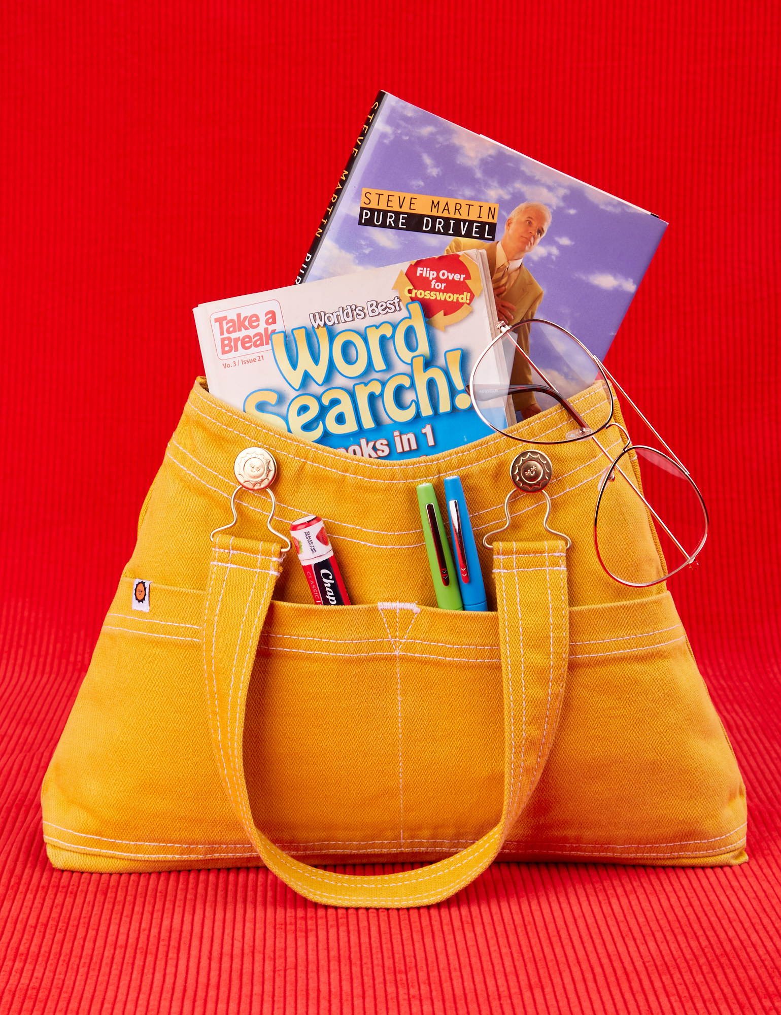 Overall Handbag in Mustard Yellow with two books inside main compartment of bag