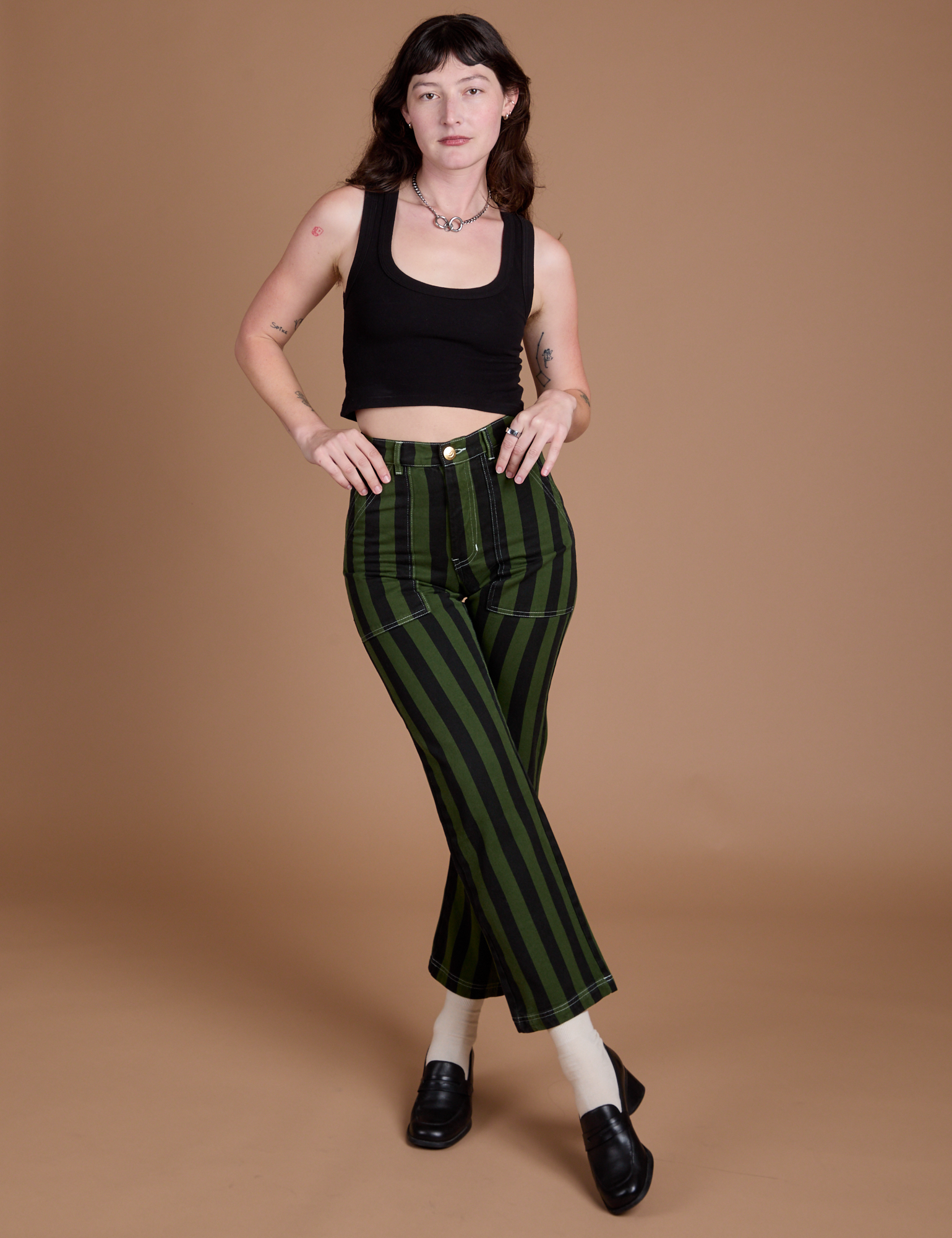 Alex is wearing Black Stripe Work Pants in Evergreen and black Cropped Tank