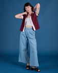 Alex is wearing Painted Pantry Button-Up in Red Wine and light wash Wide Leg Trousers