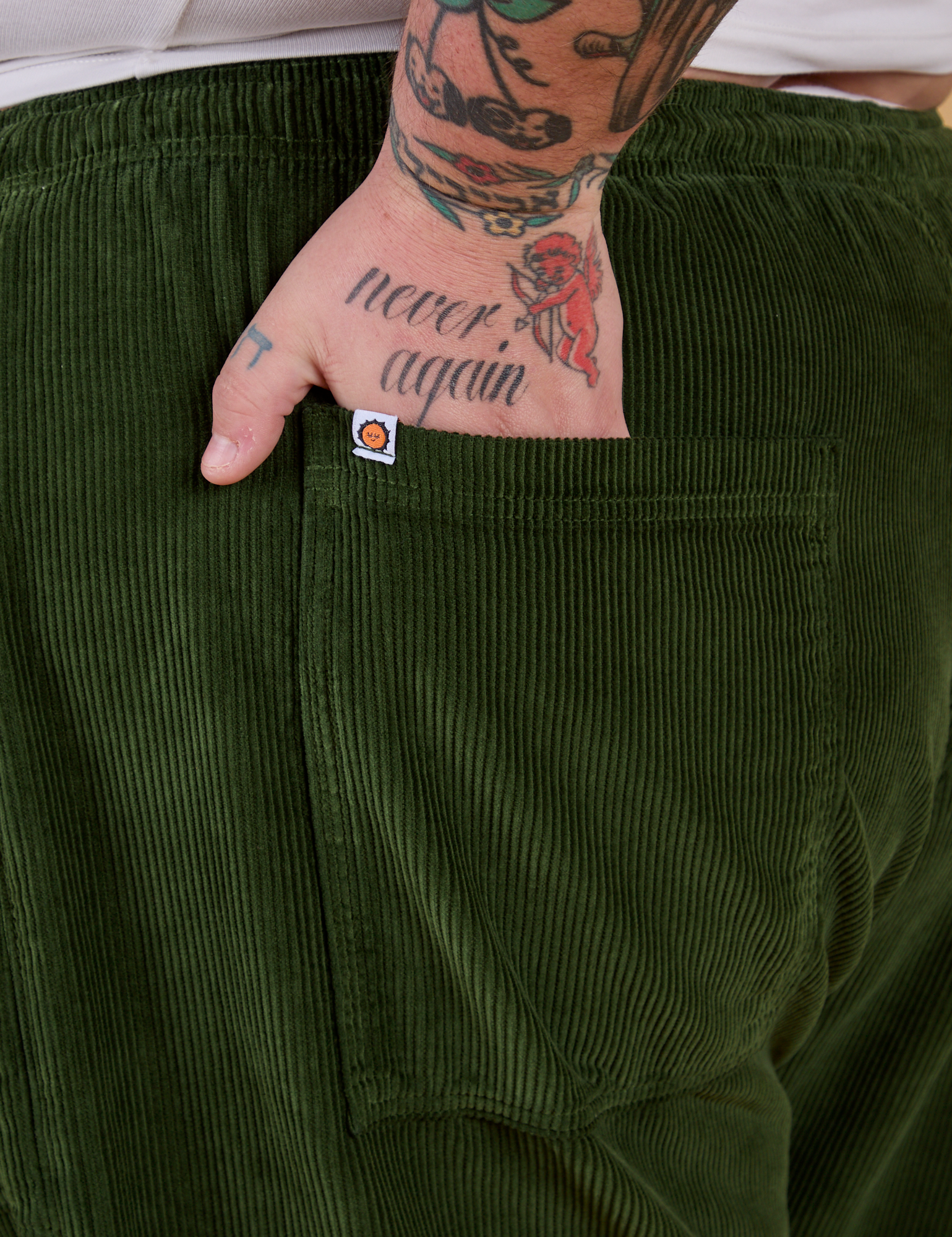Close up of Sam's hand in the back pocket of Corduroy Drop Pocket Cargo Pants in Evergreen