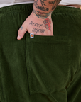 Close up of Sam's hand in the back pocket of Corduroy Drop Pocket Cargo Pants in Evergreen
