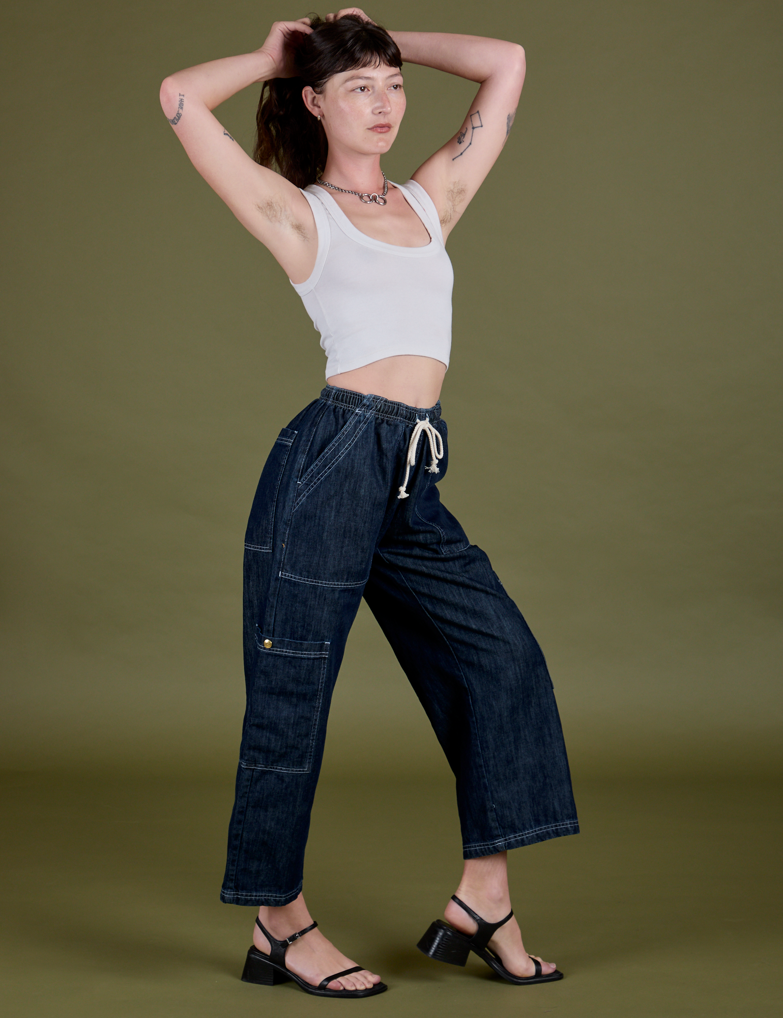 Side view of Denim Drop Pocket Pants in Dark Wash and Cropped Tank in Vintage Tee White on Alex