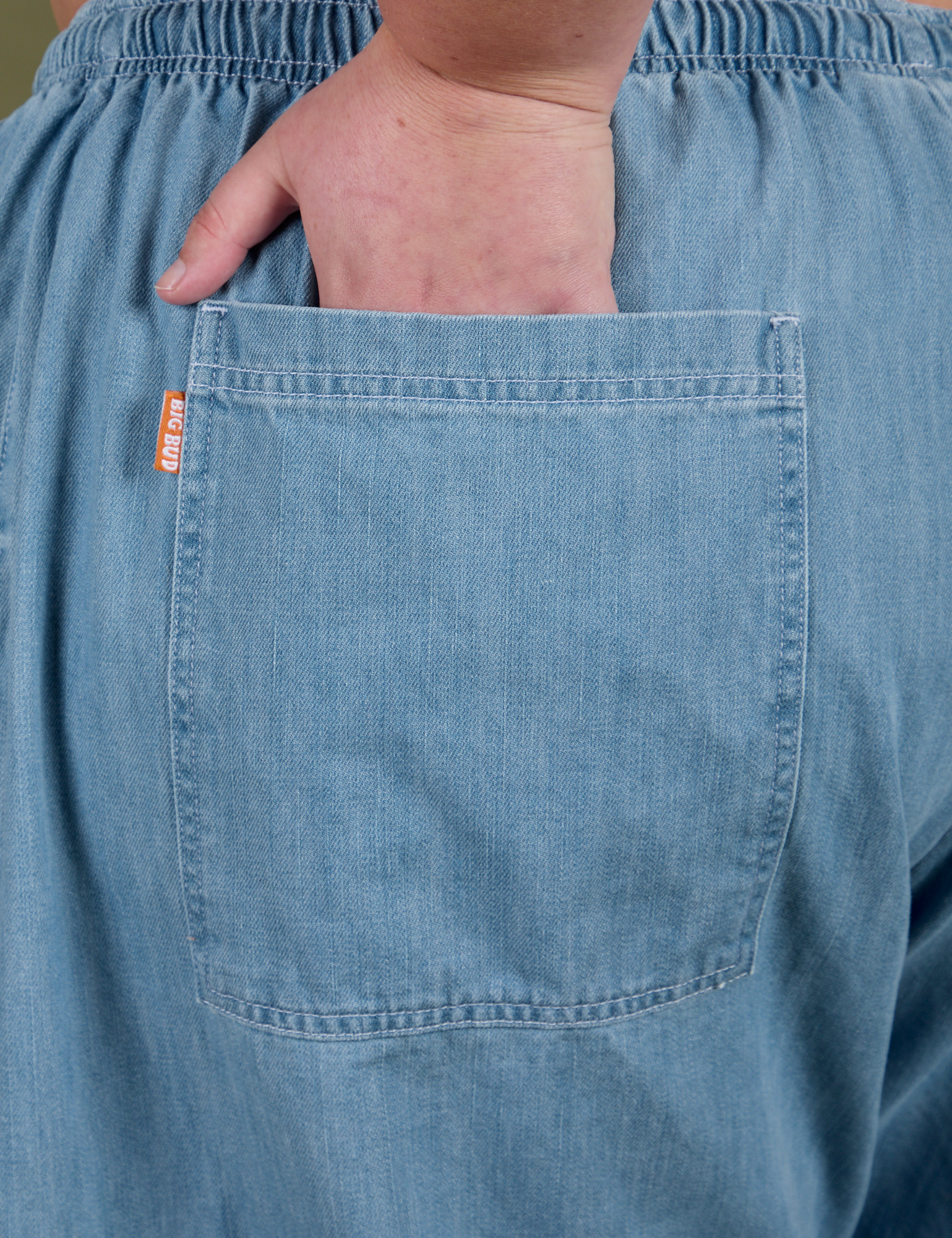 Close up of Juliet's hand in the back pocket of Denim Drop Pocket Pants in Light Wash