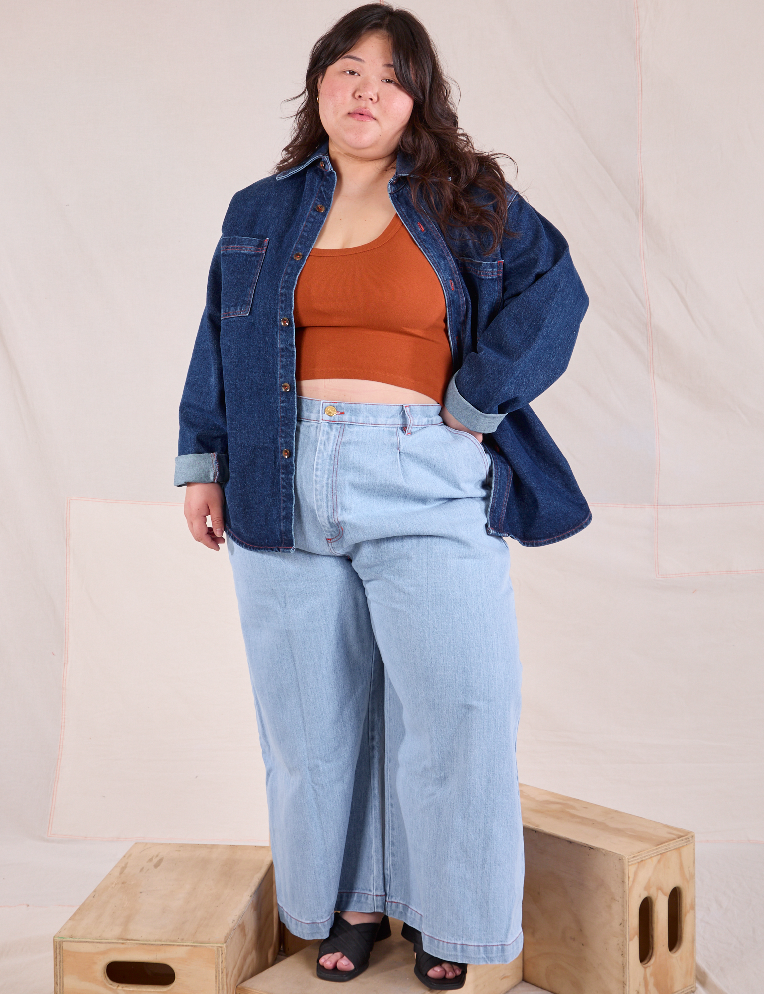 Ashley is wearing Denim Overshirt in Dark Wash, burnt terracotta Cropped Tank and light wash Wide Leg Denim Trousers