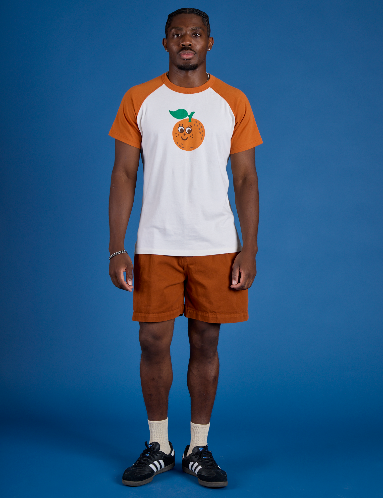 Isaac is wearing Produce Raglan Tee in Orange
