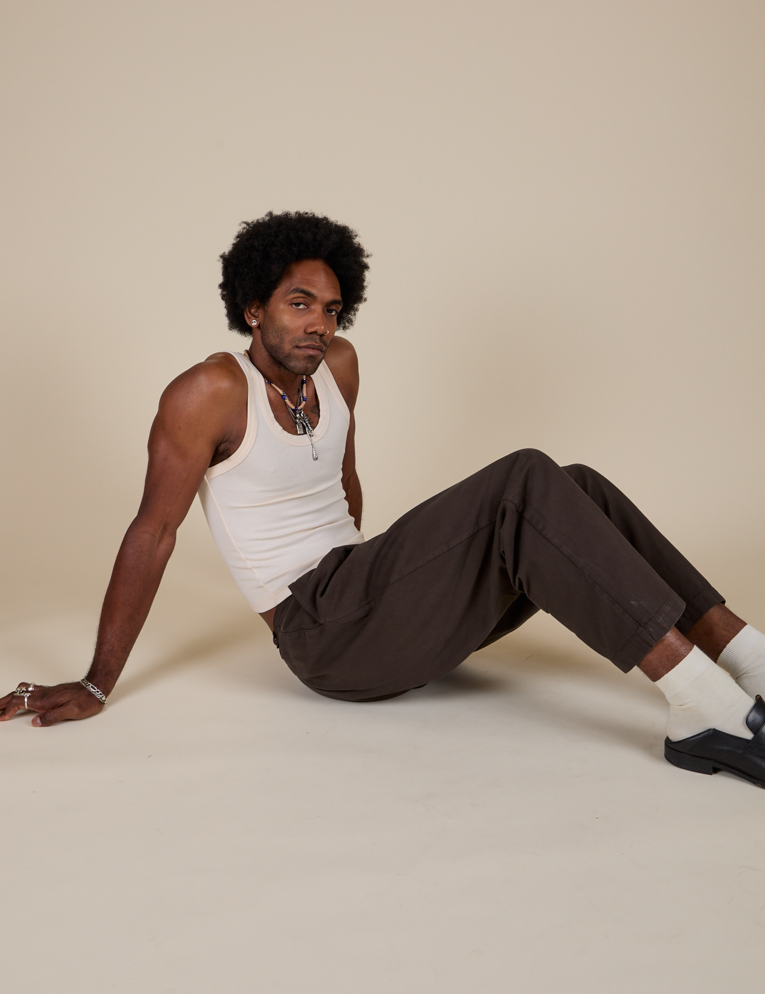 Jerrod is wearing Heavyweight Trousers in Espresso Brown and Tank Top in Vintage Tee Off-White