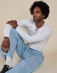 Jerrod is wearing Long Sleeve Baby Tee in Vintage Tee Off-White