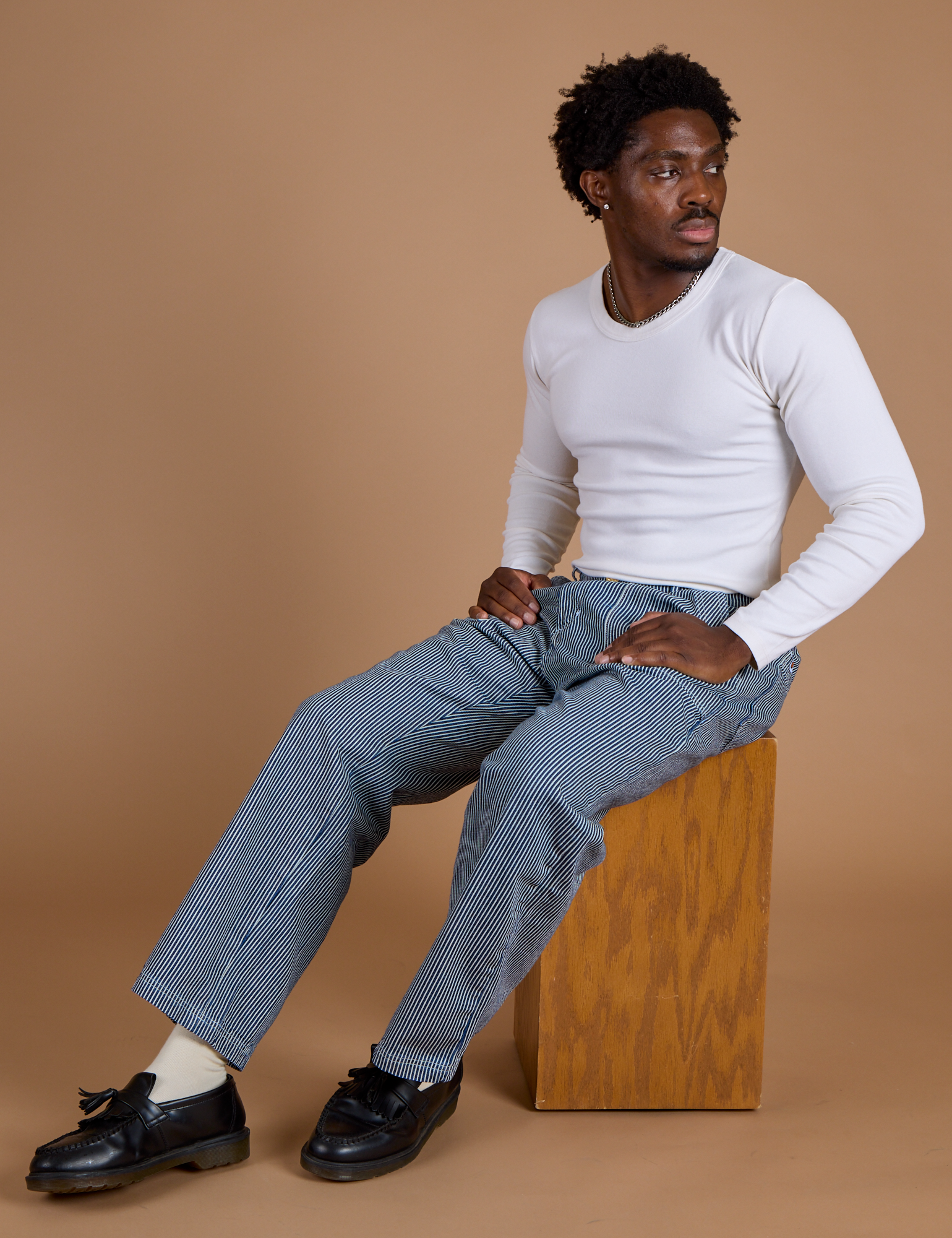 Isaac is wearing Railroad Denim Work Pants in Natural and vintage tee white Long Sleeve Baby Tee