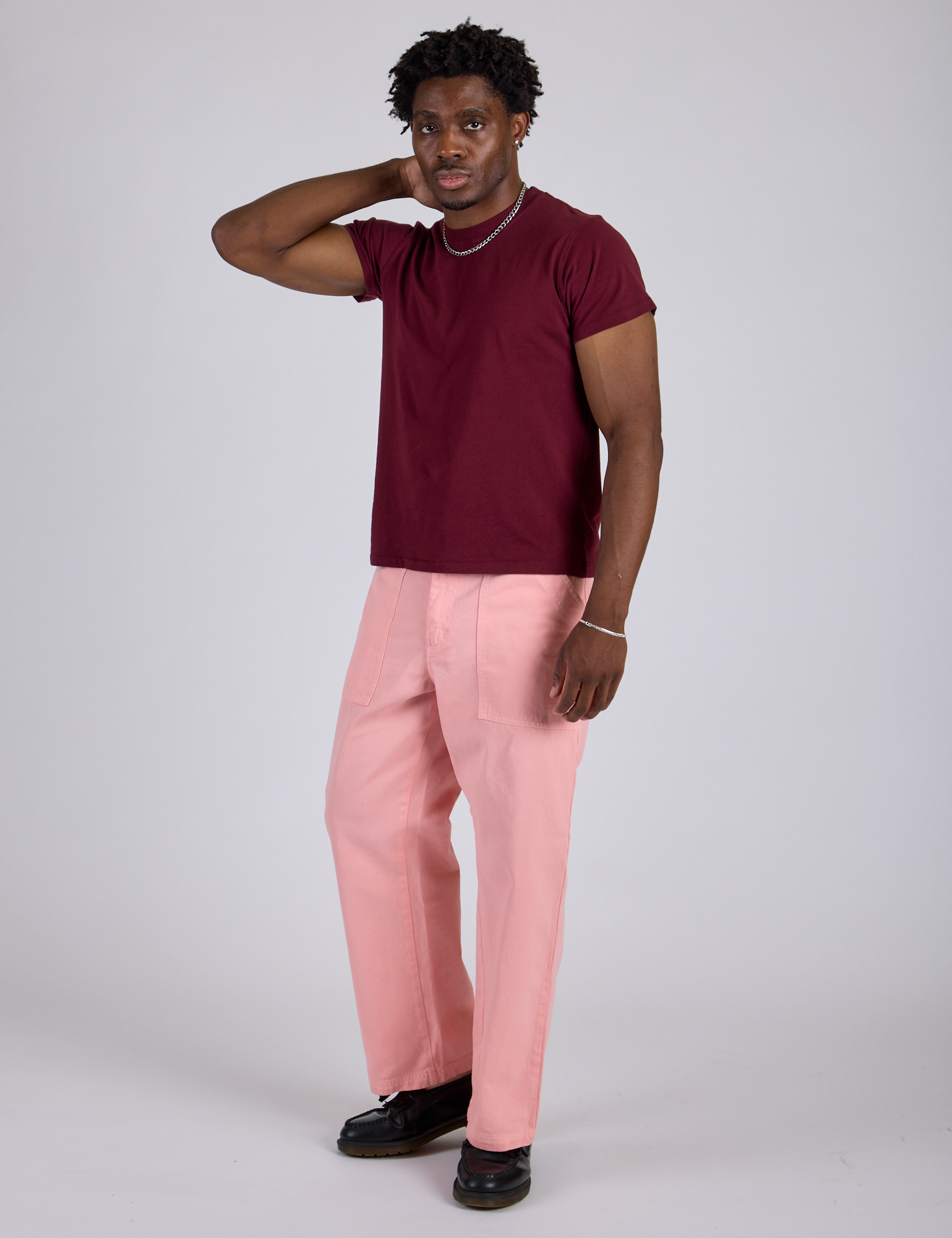Angled front view of Work Pants in Baby Pink and red wine Organic Vintage Tee on Isaac