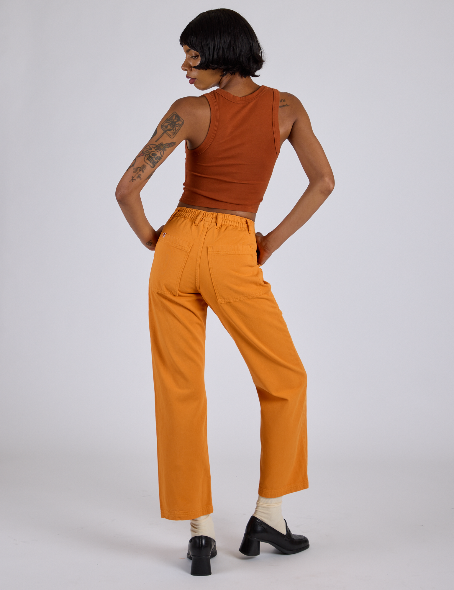 Back view of Work Pants in Creamsicle Orange and burnt terracotta Cropped Tank on Kira