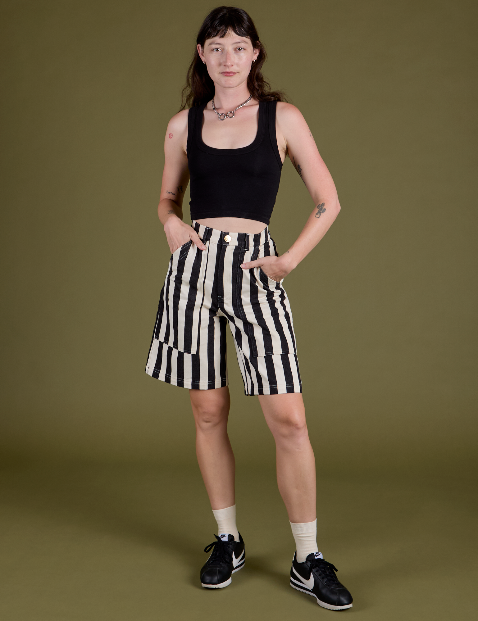 Alex is 5’8” and wearing XXS Longline Work Shorts in Natural paired with black Cropped Tank