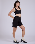 Angled front view of Pleated Trouser Shorts in Basic Black and black Mini Tank on Alex