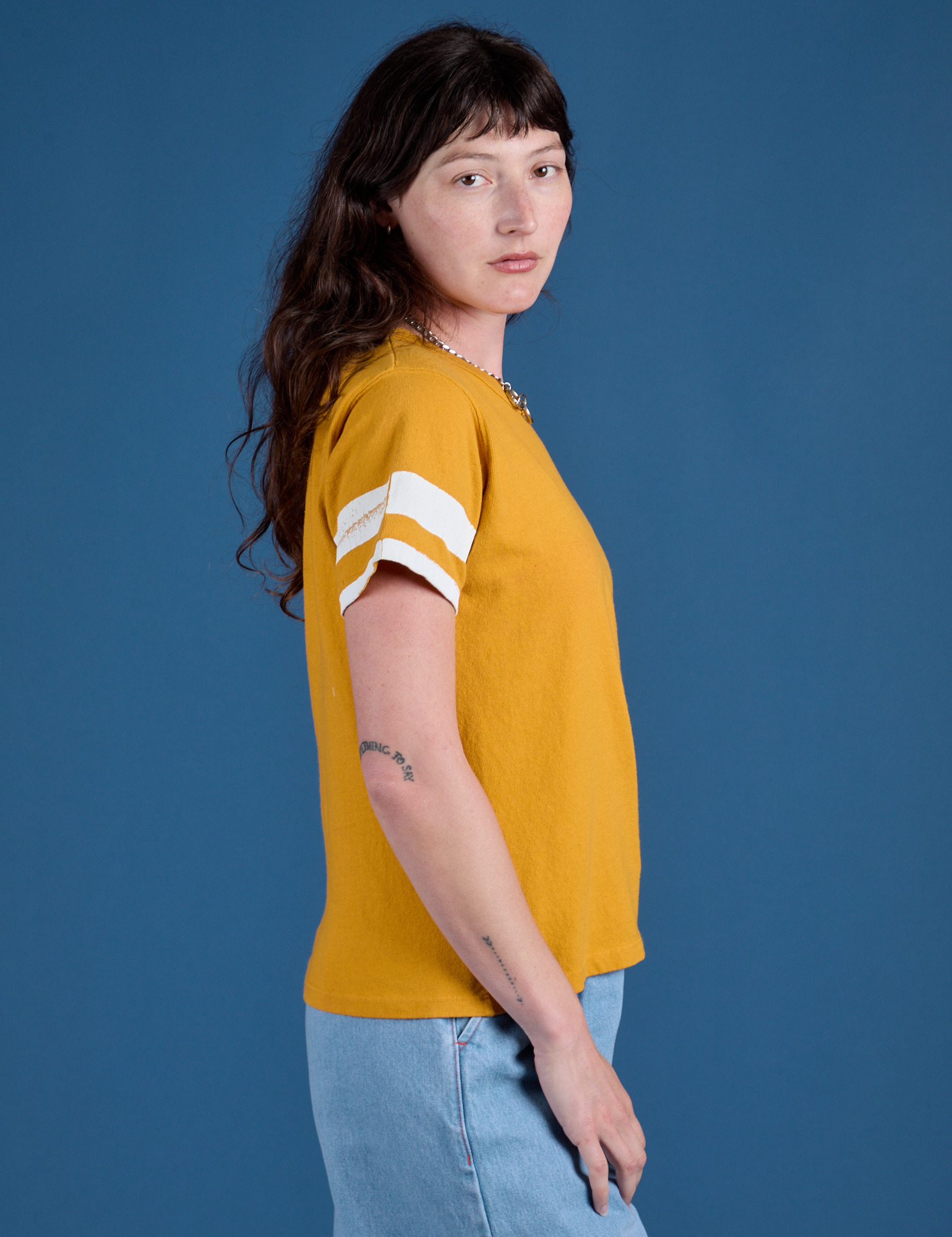 Painted Burly Tee in Mustard Yellow side view on Alex