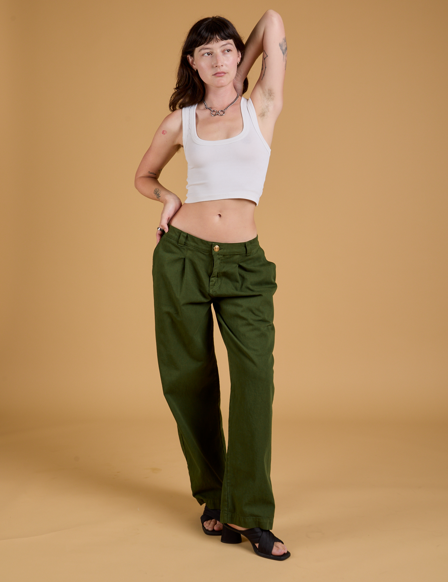 Alex is 5'8" and wearing XXS Baggy Mid-Rise Trousers in Evergreen paired with a vintage tee white Cropped Tank