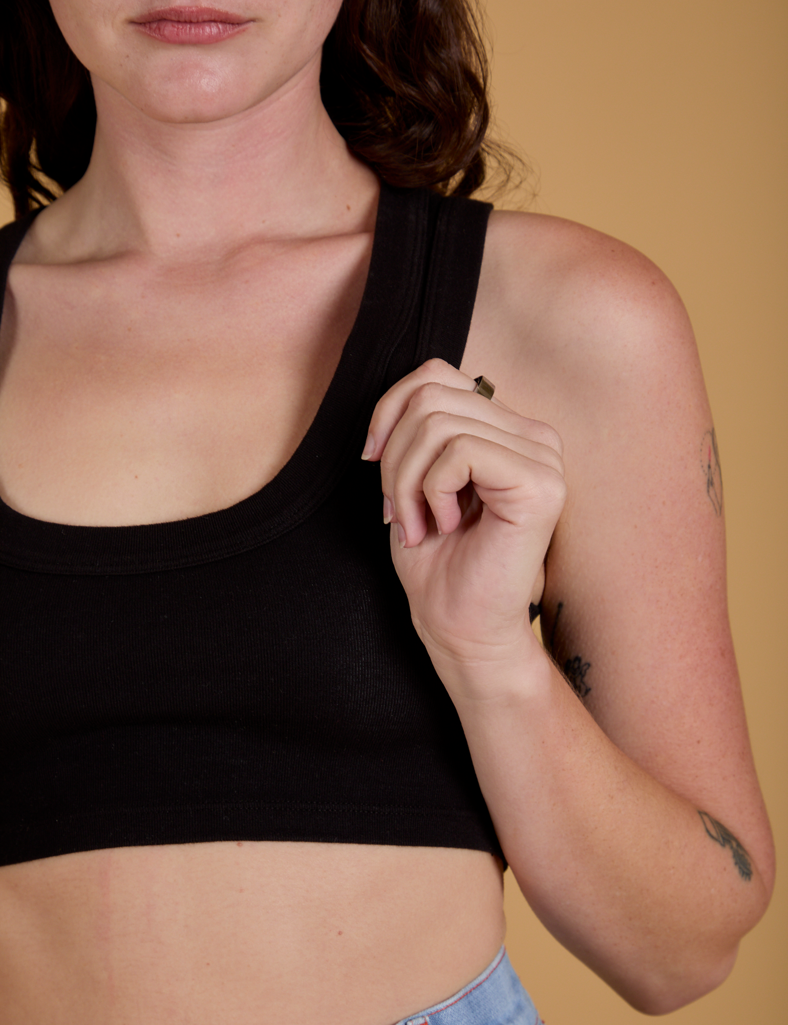 Front close up of Mini Tank in Basic Black on Alex holding the strap