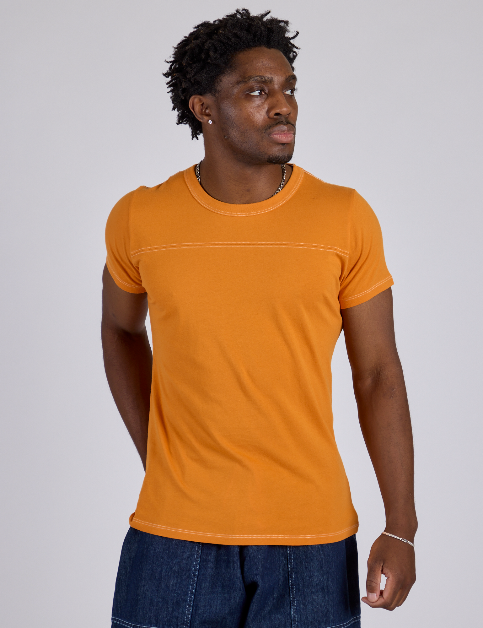 Isaac is wearing Jr. Varsity Tee in Creamsicle Orange