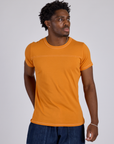 Isaac is wearing Jr. Varsity Tee in Creamsicle Orange