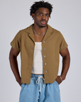 Isaac is wearing Pantry Button-Up in Desert Brown