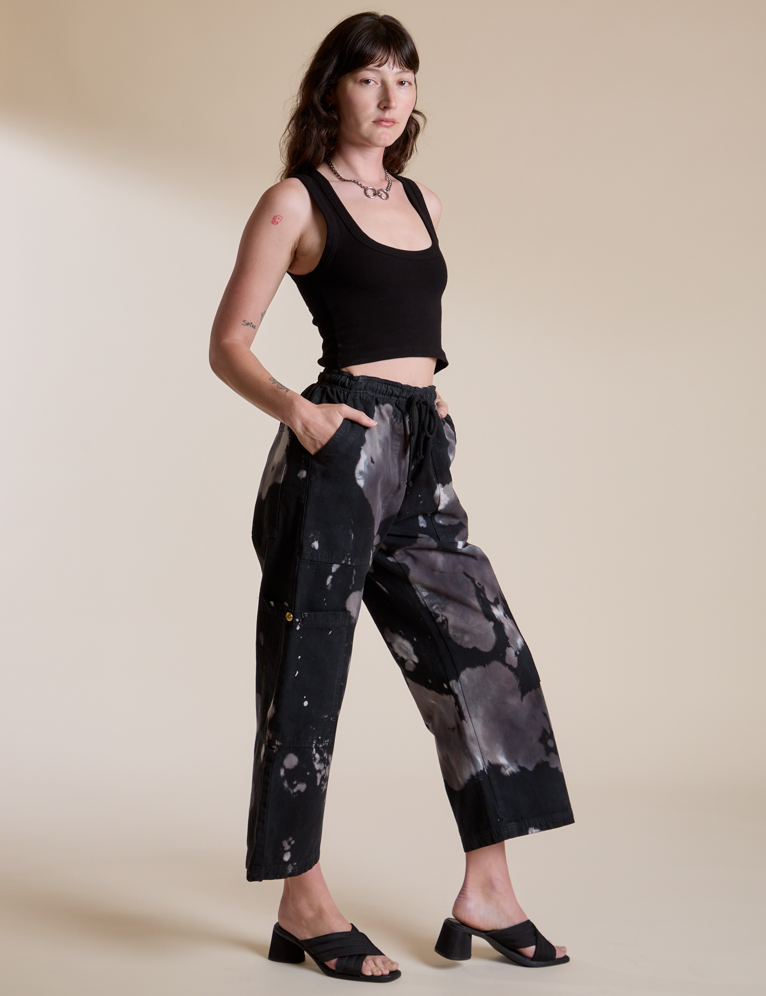Angled front view of Magic Waters Drop Pocket Pants in Ink Blot and black Cropped Tank on Alex