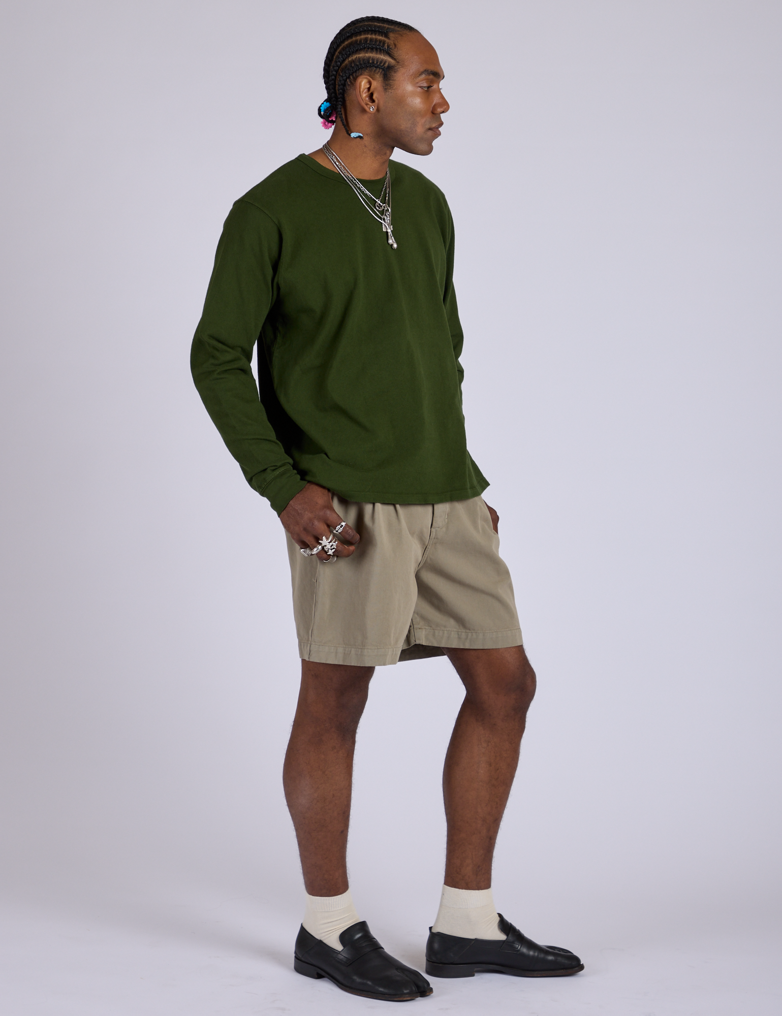 Angled front view of Pleated Trouser Shorts in Khaki Grey and evergreen Long Sleeve Burly Tee on Jerrod