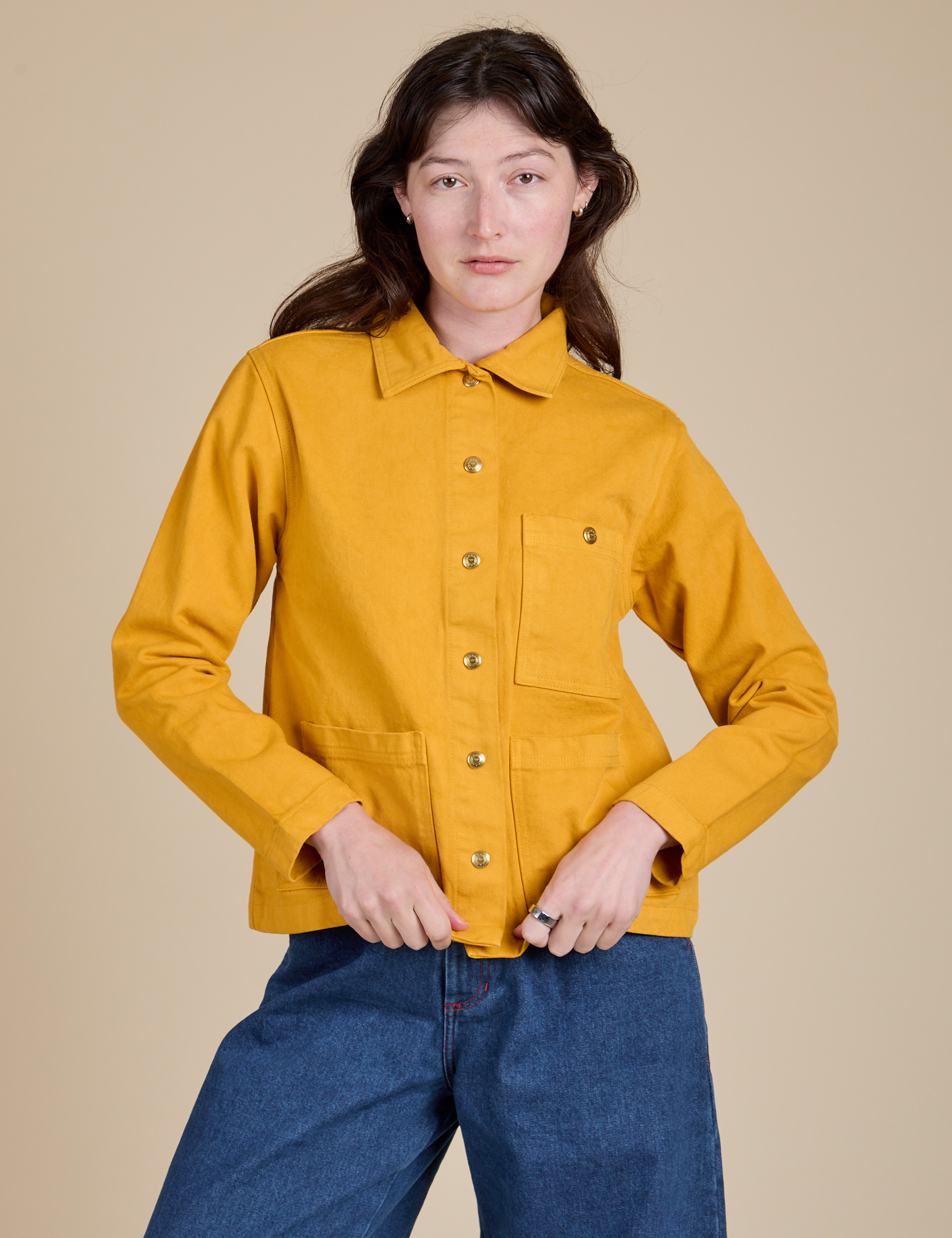 Alex is wearing a buttoned up Denim Work Jacket in Mustard Yellow