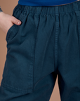 Close up of Sydney's hand in the front pocket of Action Pants in Lagoon