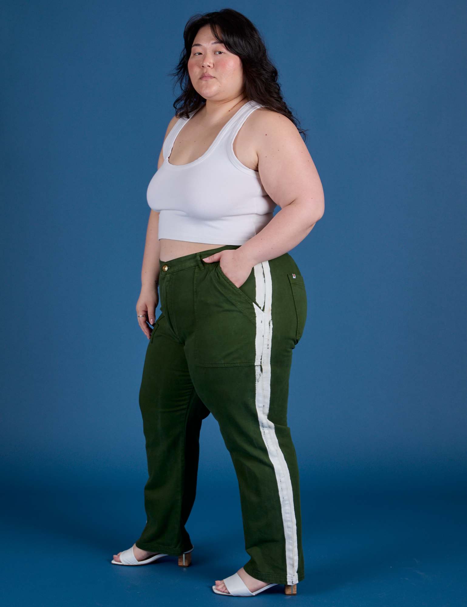 Side view of Painted Work Pants in Evergreen and vintage tee white Cropped Tank on Ashley