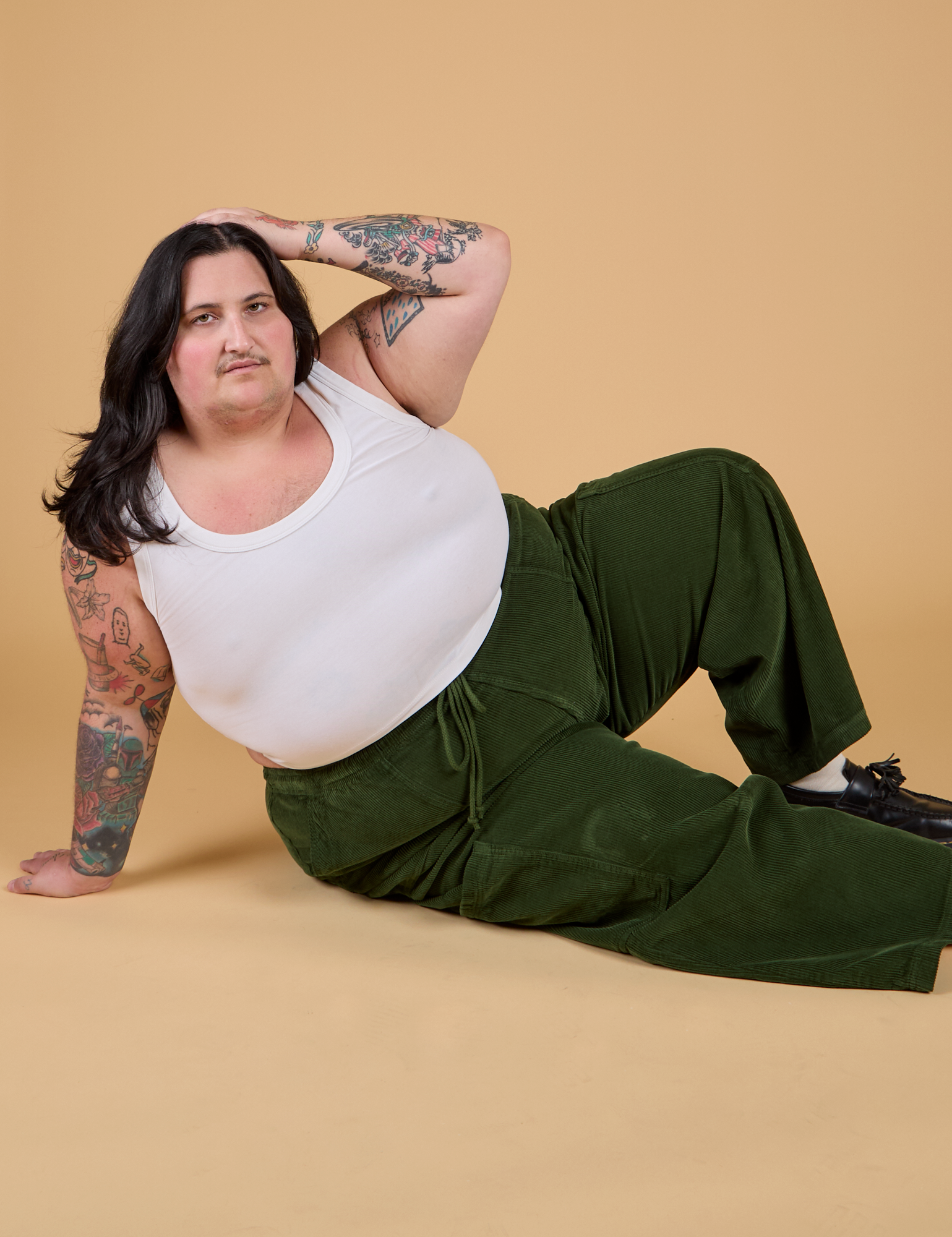 Sam is wearing Corduroy Drop Pocket Cargo Pants in Evergreen and Cropped Tank in Vintage Tee White