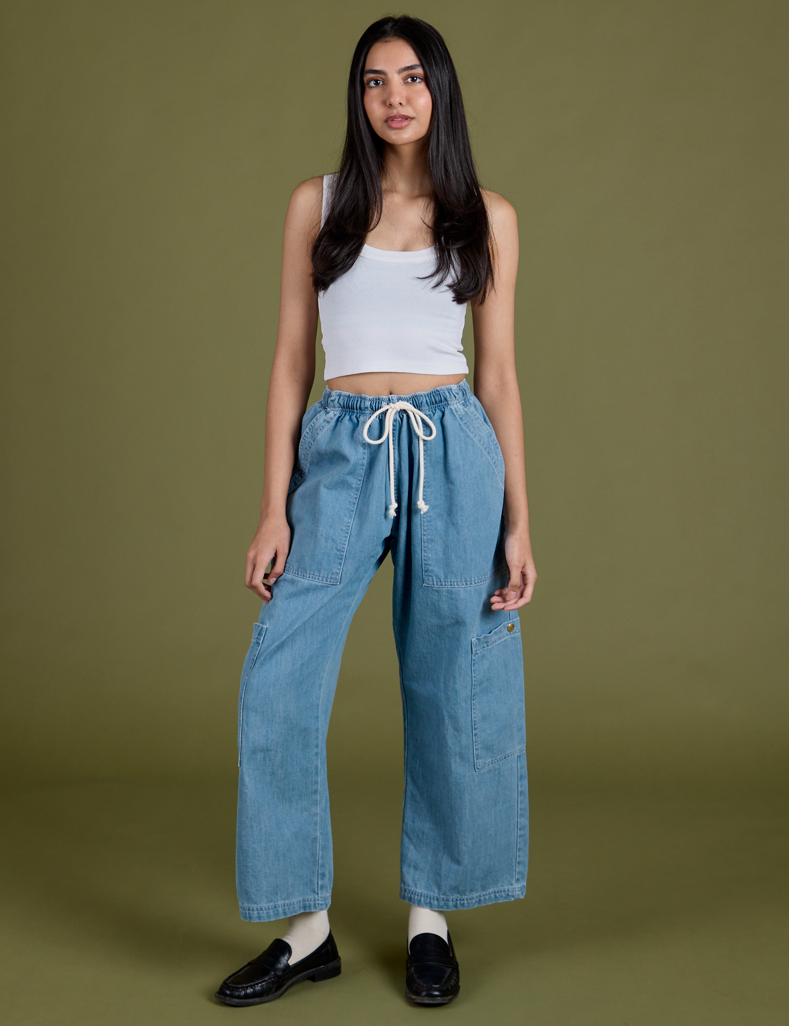 Anjaline 5'7" is and wearing XXS Denim Drop Pocket Pants in Light Wash paired with vintage tee white Cropped Tank