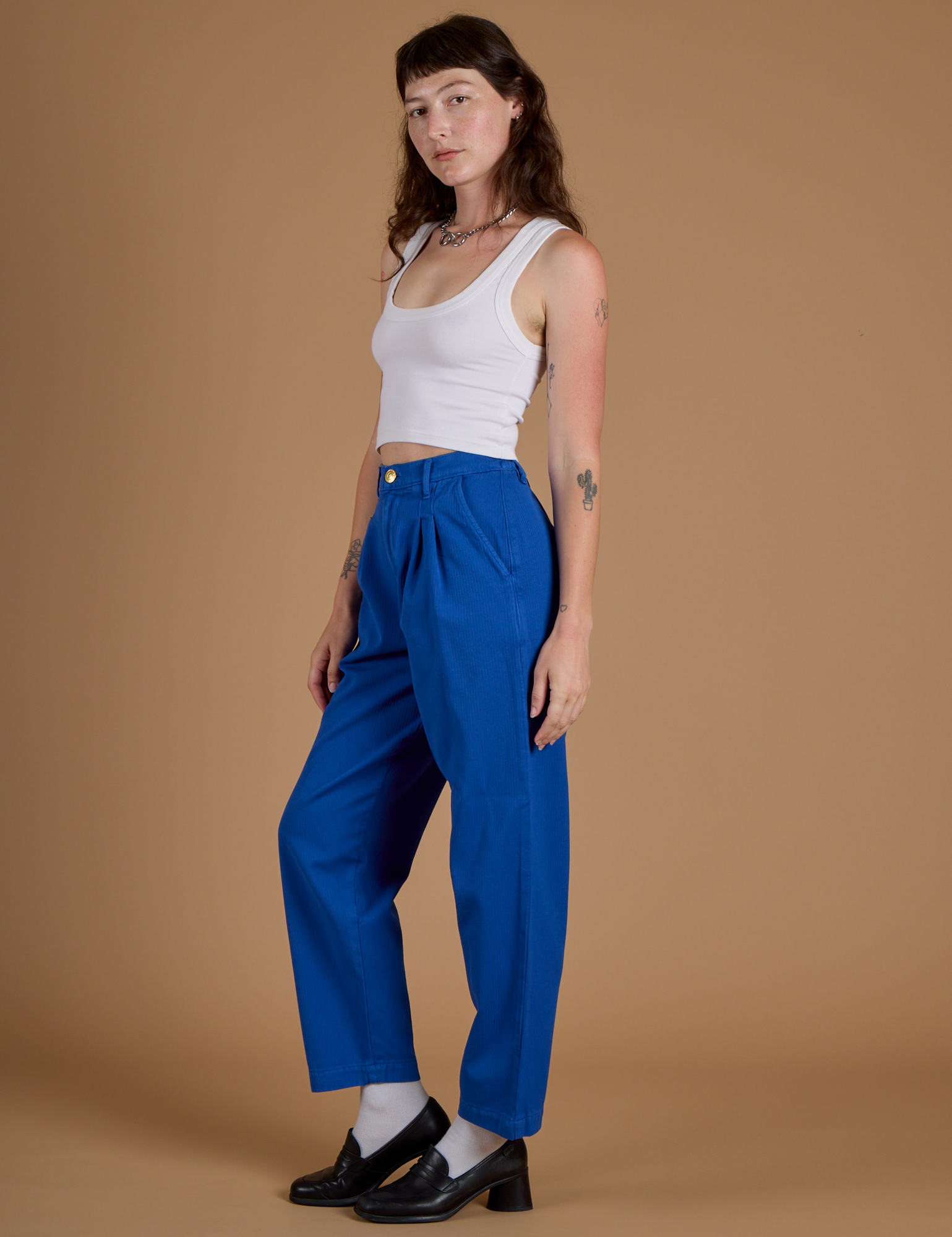 Side view of Heritage Trousers in Royal Blue and vintage tee white Cropped Tank on Alex