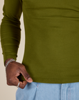 Long Sleeve Baby Tee in Summer Olive bottom close up with Jerrod holding the hem