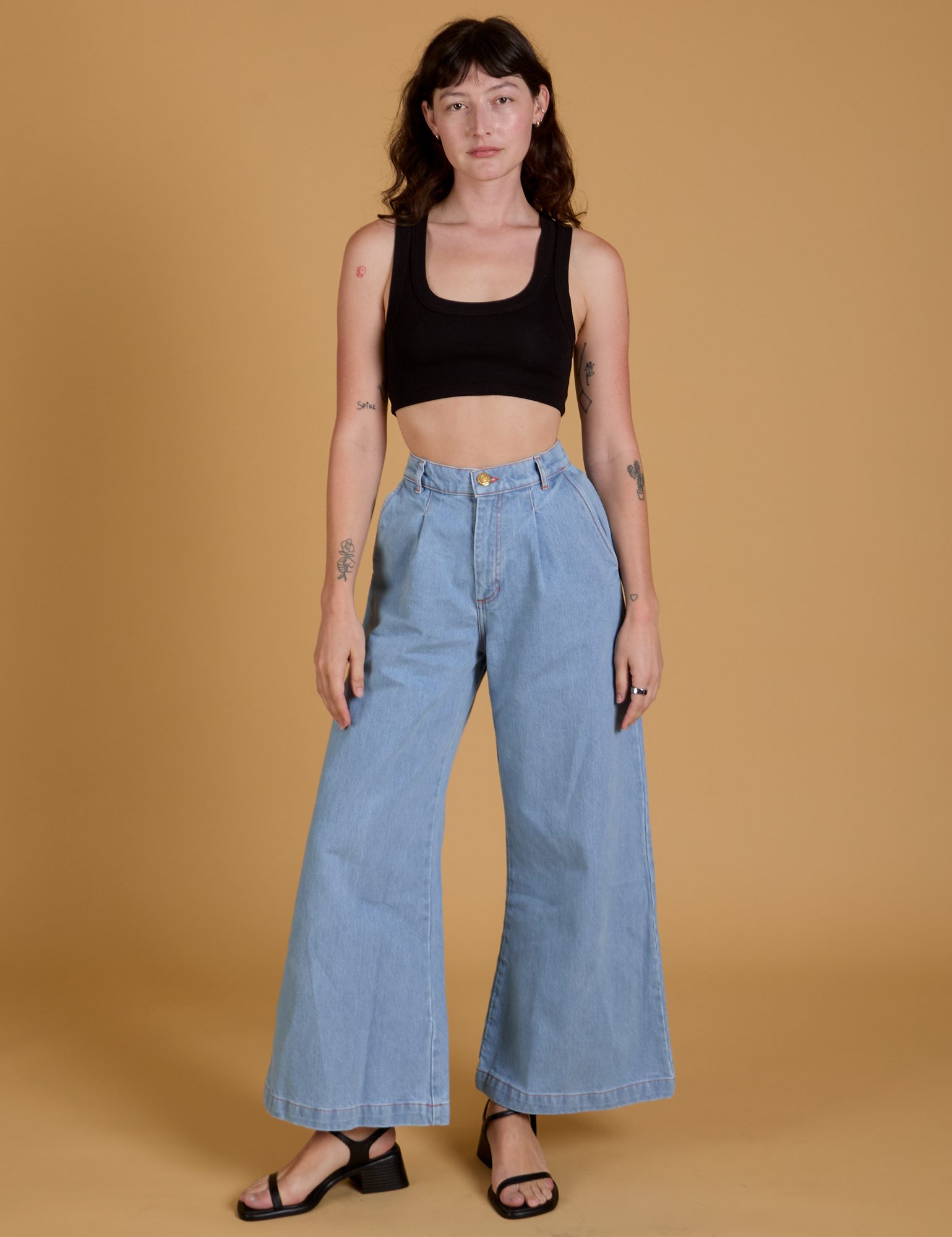 Alex is wearing Mini Tank in Basic Black and light wash Indigo Wide Leg Trousers