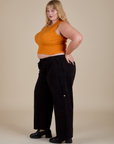 Side view of  Muscle Tee in Creamsicle Orange and black Drop Pocket Cargo Pants on Juliet